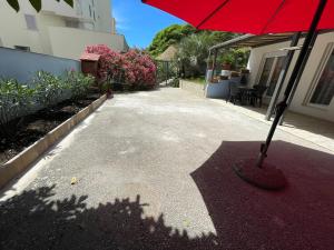 a red umbrella sitting on top of a driveway at Apartments Znjan in Split