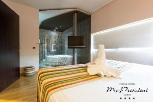 ein Schlafzimmer mit einem Bett mit einer Badewanne und einem TV in der Unterkunft Design Hotel Mr President in Belgrad