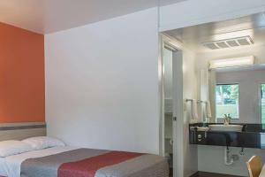 a bedroom with a bed and a sink and a mirror at Motel 6-Goodlettsville, TN - Nashville in Goodlettsville