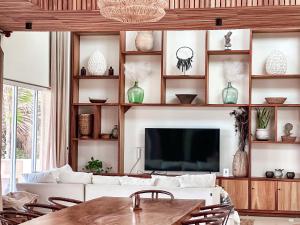 a living room with a white couch and a tv at 15 minutes from Tulum - Siete Gotas in Tulum