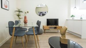 une salle à manger avec une table et des chaises en verre dans l'établissement Apartamento Comercio 37 by Toledo AP, à Tolède