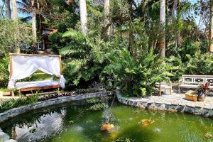 un jardín con un estanque con una cometa. en Taman Búzios Hotel, en Búzios