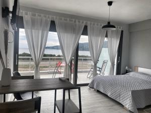 1 dormitorio con cama, mesa y ventana grande en Maurizio's Villa, en Yiáltra