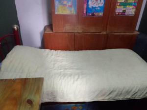 a bedroom with a bed with a wooden table at Dormitorio Privado in La Cieneguita