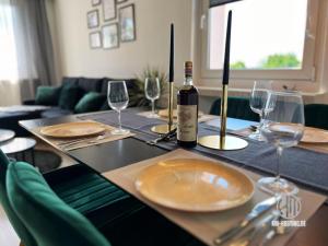 a table with a bottle of wine and wine glasses at KMHosting Luxe Apartment Chemnitz-Zentrum in Chemnitz