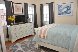 a bedroom with a bed and a dresser with a tv at The 87th House in Portland