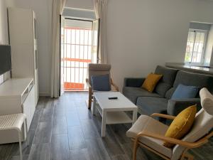 ein Wohnzimmer mit einem Sofa und einem Tisch in der Unterkunft Apartamento Cañebolo in La Puebla de los Infantes
