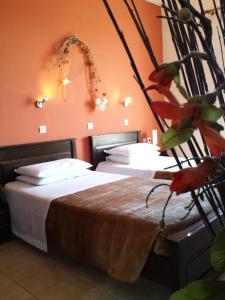 2 camas en una habitación con paredes de color naranja en Kos Island Studios, en Kefalos