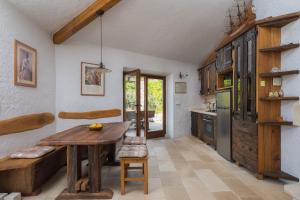 een keuken met een houten tafel en een koelkast bij Villa Viva Brac - Pool - Meerblick in Povlja