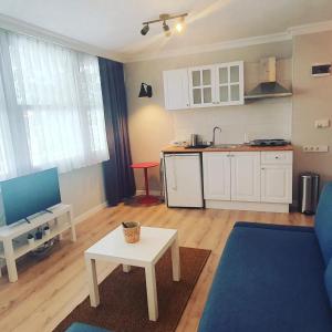 a living room with a table and a kitchen at Antik Apartments Marmaris in Marmaris