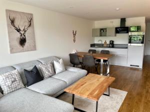 a living room with a couch and a table at Apartment BERGseetraum - Bergblick, neu renoviert, gemütlich, familienfreundlich in Schliersee +12 photos