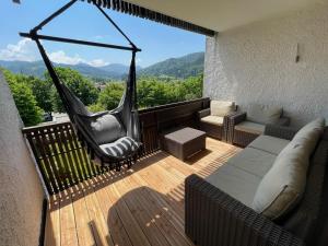 a hammock on a balcony with a view of the mountains at Apartment BERGseetraum - Bergblick, neu renoviert, gemütlich, familienfreundlich in Schliersee