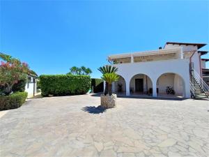 a house with a palm tree in the middle of a courtyard at Oasi del Borgo in Borgo Bonsignore