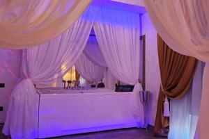 a room with a bath tub with pink curtains at Hotel Boutique Mikaela (Adult Only) in Braşov