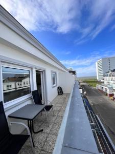 a balcony with a table and chairs on a building at Hotel Paula Norderney in Norderney
