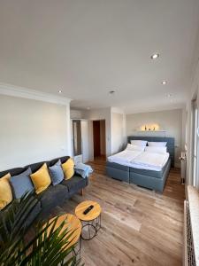 ein Schlafzimmer mit einem großen Bett und einem Sofa in der Unterkunft Hotel Paula Norderney in Norderney