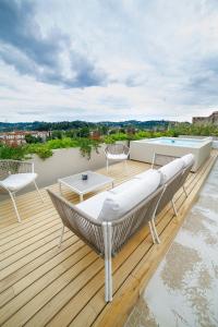 um deque com um sofá e cadeiras e uma piscina em The Rooftop em Florença