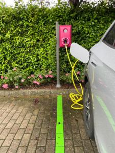 a car plugged into a parking meter with a yellow hose at Hotel Mirandola in Mirandola