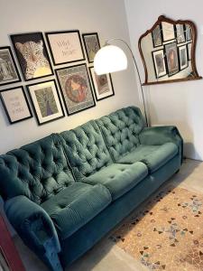 un sofá verde en una sala de estar con cuadros en la pared en Villa Vintage Dulcinea, en Camuñas