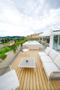 um deque com mobiliário branco e uma piscina em The Rooftop em Florença