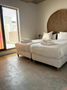 a bedroom with two beds and a large window at Villa Vintage Dulcinea in Camuñas