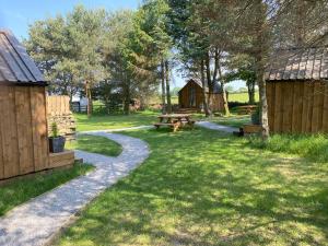a garden with a picnic table and a bench at Cow Close Camping Pods in Leyburn