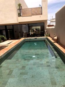 a swimming pool in front of a house at Villa Vintage Dulcinea in Camuñas