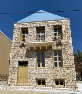 a stone building with a balcony on top of it at To Petrino in Meyisti