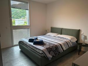 1 dormitorio con cama verde y ventana en LabPark design apartment en Melano