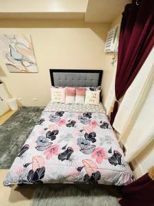 a bedroom with a bed with a floral bedspread at * *K Irresistable value for 3 in Iloilo City