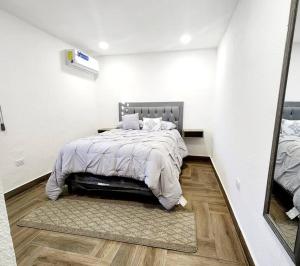 Habitación blanca con cama y espejo en Departamento Pitagoras No 2 en Ciudad Juárez