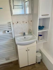 a white bathroom with a sink and a shower at Pensilva in Hayle