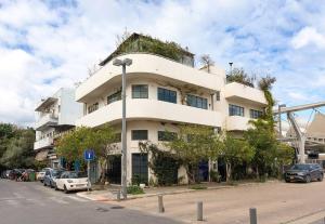 a large white building with an ivy covered roof at A Bauhaus Gem - Prime Location in Tel Aviv
