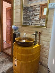 uma casa de banho com um lavatório em cima de um barril em Satul de Vacanța Carla em Stremţ