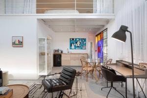 a living room with a table and chairs and a kitchen at A Bauhaus Gem - Prime Location in Tel Aviv