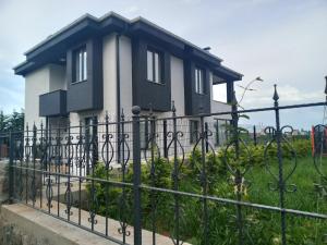 uma casa atrás de uma cerca de ferro forjado em MİRAY SUİTE VİLLA em Trebizonda
