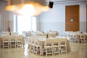 亚实基伦Tamara Ashkelon Hotel的摆着白色桌子和椅子的宴会厅