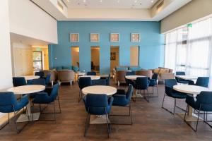 - une salle d'attente avec des tables et des chaises dans l'établissement Tamara Ashkelon Hotel, à Ashkelon