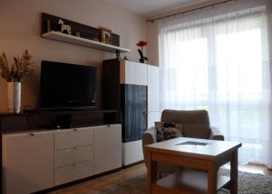 salon z telewizorem, krzesłem i stołem w obiekcie Apartament SYLVIA Self Check-In Netflix w mieście Rzeszów