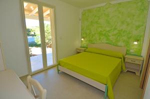 a bedroom with a green bed and a window at B&B Lu Cantoru in Marina di Pescoluse