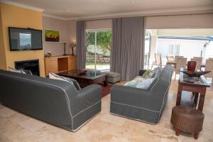 a living room with two couches and a television at Sunset Haven in Knysna