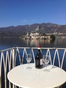 uma garrafa de vinho sentada numa mesa com dois copos em -Ortaflats- Appartamento L'Angolo em Orta San Giulio