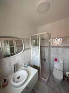 uma casa de banho com um lavatório, um chuveiro e um WC. em Adraga Beach&Village House em Colares