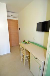 a room with a desk and a television on the wall at B&B Lu Cantoru in Marina di Pescoluse