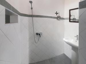 a white bathroom with a shower and a sink at Hotel-Restaurant Le Kaouki in Sidi Kaouki +37 photos