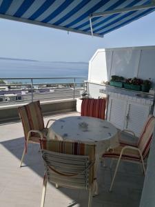 a table and chairs on a balcony with a view of the ocean at Apartments Znjan in Split