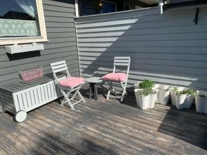 two chairs and a table on a porch with plants at Dobbeltrom in Moss