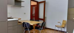 una pequeña cocina con mesa de madera y sillas en Pisa Central Station Room Rent, en Pisa