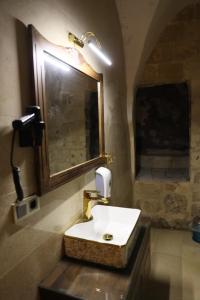 uma casa de banho com um lavatório branco e um espelho. em Mardin Bey Konağı Hotel em Mardin