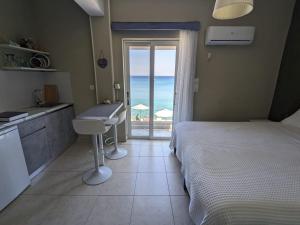 Schlafzimmer mit einem Bett und Meerblick in der Unterkunft Pillbox Seafront Studios and Apartments in Kardamaina
